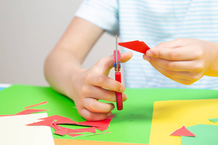 儿童手用剪刀在桌子上剪彩色纸