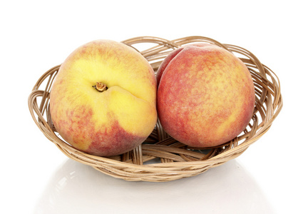 成熟的桃子在篮子上白色隔离