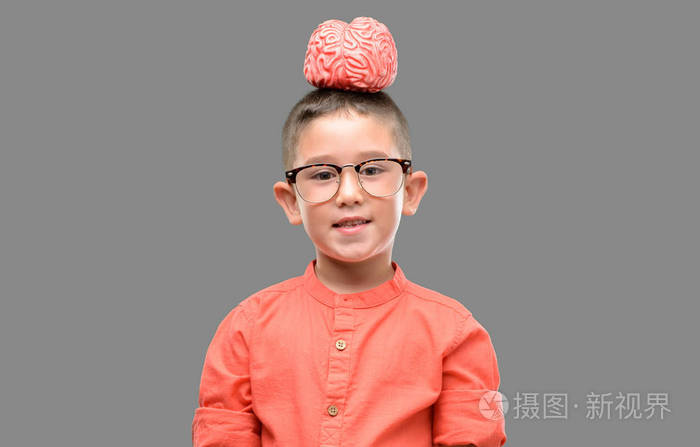 戴眼镜的黑发小孩抱着一张快乐的脸站着微笑着带着自信的微笑露出了