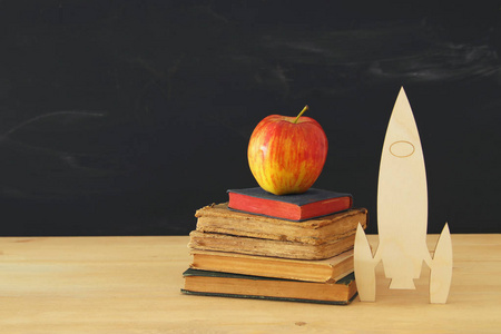 回到学校的概念。在教室黑板前面的书旁边的木 rocketand 铅笔