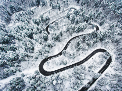 雪路在森林里。高山上的极端蜿蜒的道路