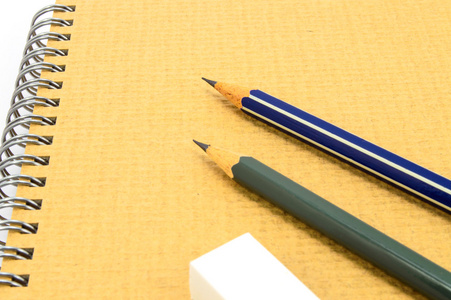 两个木制铅笔和橡皮擦上的回收站在白色背景上的笔记本