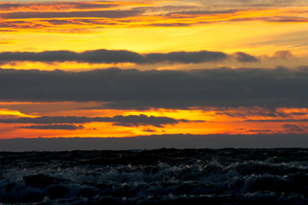 暴风雨的大海对着夕阳的背景。剧烈的天空在风暴海