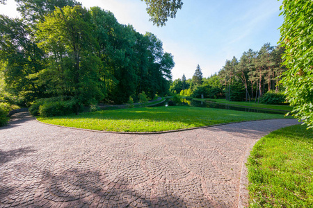 这条小路是在夏日阴天的一个美丽的绿色公园里铺设了一块石头铺成的。一个在湖边放松的好地方