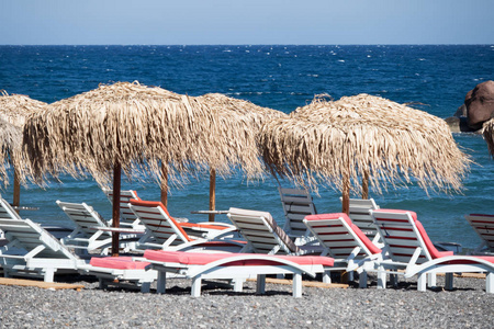 圣托里尼带雨伞和甲板椅的热带海滩