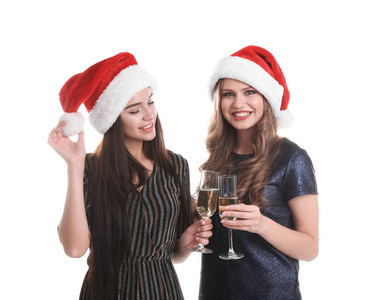 美丽的年轻女子在圣诞老人的帽子上, 在白色的背景香槟杯。圣诞庆典
