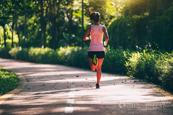 健康妇女赛跑者奔跑在早晨公园路照片-正版商用图片