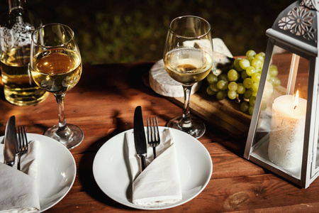浪漫晚餐与一杯酒和小吃在一个老木桌上的夏日傍晚