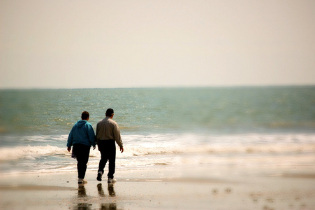 在沙滩上散步的老夫妇
