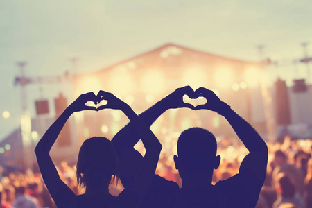 情侣在音乐会上塑造了一个心形