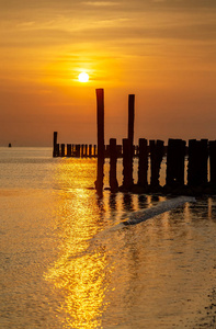 荷兰海岸线上的夕阳与木杆