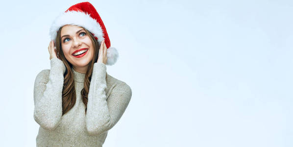 微笑的年轻女子穿着圣诞老人帽子。孤立的肖像