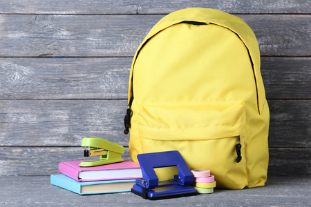 黄色背包与学校供应在木背景