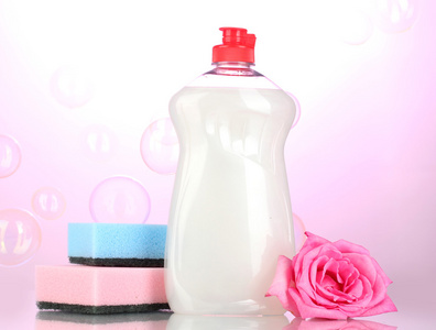 洗洁精与海绵和粉红色的背景上的花