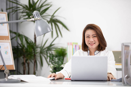 亚洲妇女使用膝上型电脑, 在家工作。亚洲妇女生活方式概念