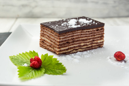 黑巧克力素食蛋糕与糖果和坚果在木背景