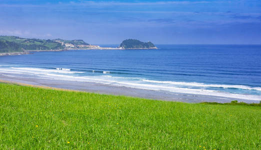 草甸和海滩在城市 Zarautz 与海岛 San 安东 博卡拉顿 de 戈塔瑞 在背景, 巴斯克国家