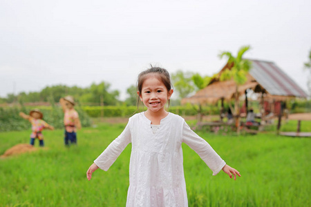 可爱的小亚洲女孩舒展胳膊在新鲜的绿色稻田