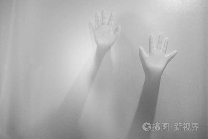 在磨砂玻璃后面的女人的影子手模糊的手抽象万圣节背景黑白图片