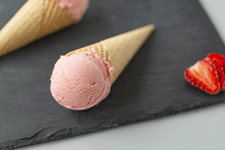 草莓冰淇淋在石板板上的华夫饼锥