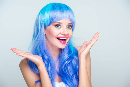兴奋的年轻妇女与明亮的蓝色头发隔绝灰色
