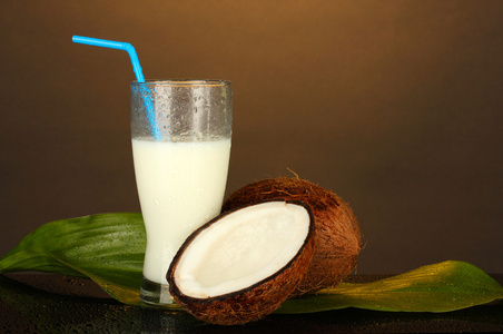 杯椰子牛奶和椰子上棕色背景特写