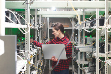 妇女与膝上型计算机在 cryptocurrency 采矿场工作