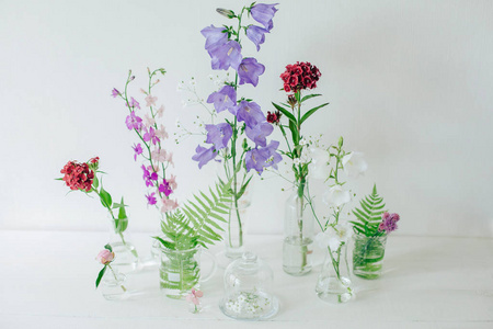 美丽的构图与香水样品和鲜花在桌子上。花在烧瓶里。野花。夏日花束