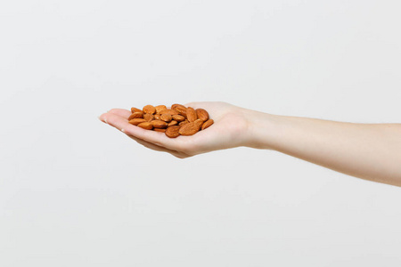 关闭女性手持棕色未加工的杏仁坚果在白色背景下分离。适当的营养, 素食素食饮食, 健康的生活方式节食概念。复制空间。广告