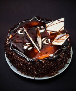 黑色背景下的小巧克力蛋糕和白色巧克力的装饰