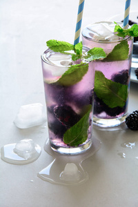 在灰色的木质背景下, 用黑莓冰和薄荷清新柠檬汁。夏日饮品概念