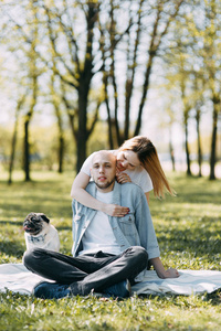 美丽的年轻夫妇在公园的一个晴朗的日子里, 爱和快乐。和狗一起散步和欢笑。婚礼前拍摄的性质。服装休闲风格与欧式加工