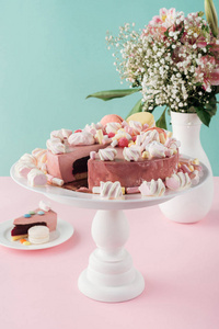 蛋糕摊上的甜蛋糕和马卡龙, 花瓶里的鲜花花束