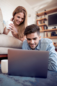 快乐的情侣在家里一起做网上购物。爱技术互联网和人的概念