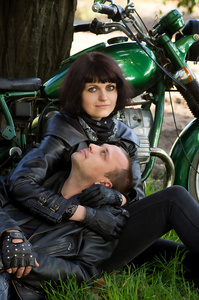 幸福的情侣附近一辆摩托车