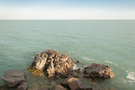 美丽的岩石海滩与海洋和山蓝天风景背景