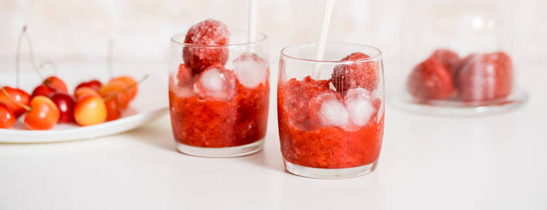 横幅一杯草莓, 樱桃冰沙在木光背景