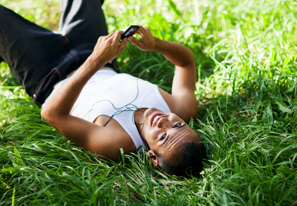 快乐的人躺在草地上和听音乐