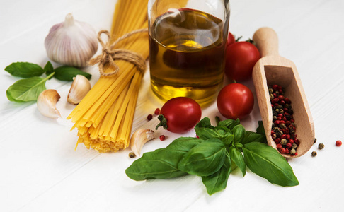 意大利食品配料, 橄榄油, 香料, 面食和西红柿在一个白色的木桌上