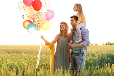 快乐的家庭与五颜六色的气球户外在晴朗的天