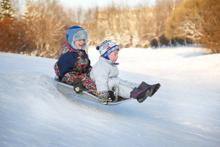 两个快乐的孩子在冬天的时候在山上滑雪