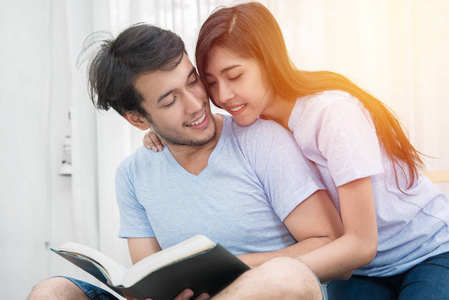 年轻爱夫妇卧室在家读书