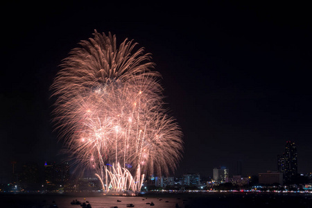 在芭堤雅国际烟花节晚上, 烟花在城市景观上探索。节日和庆祝背景