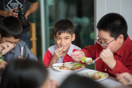 学生男孩和女孩一起午餐时间在学校食堂