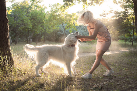 在公园散步的女孩与金猎犬