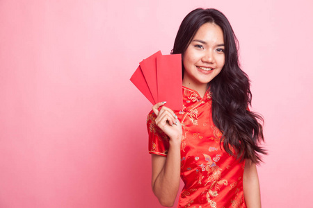 可爱的亚洲女孩在中国红色旗袍礼服红色信封粉红色背景