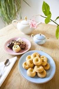 板的糕点和饼干和木桌上的茶锅