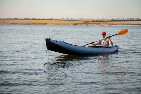 一个年轻人正在乘独木舟。宁静的海水和灿烂的阳光