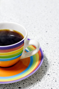 彩虹色的杯子装满热咖啡