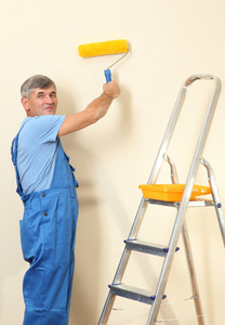 男性画家油漆墙在房间特写图片